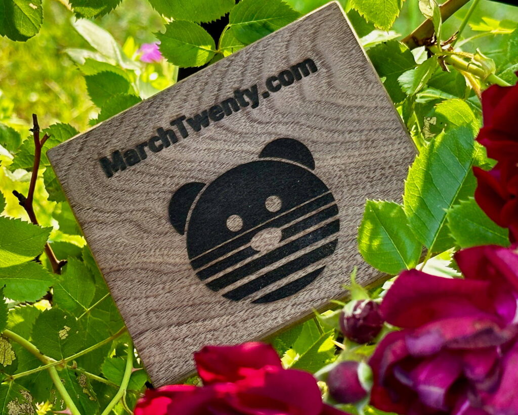 A wood block with the laser engraved Marchtwenty.com bear logo