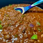 Bowl of Chili with a spoon in the pot